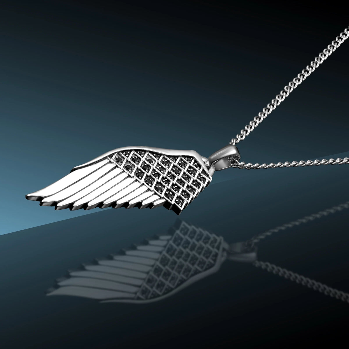 Silver wing-shaped pendant on a chain against a dark background