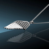 Silver wing-shaped pendant on a chain against a dark background
