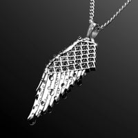 Silver wing-shaped pendant on a chain against a black background