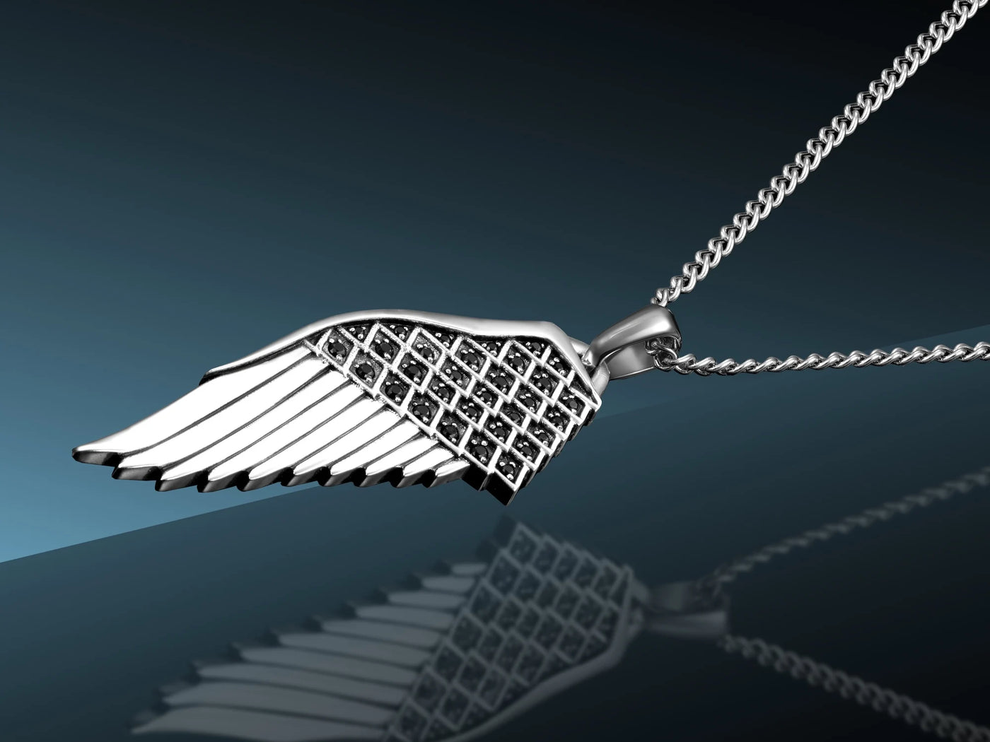 Silver wing-shaped pendant on a chain against a dark background