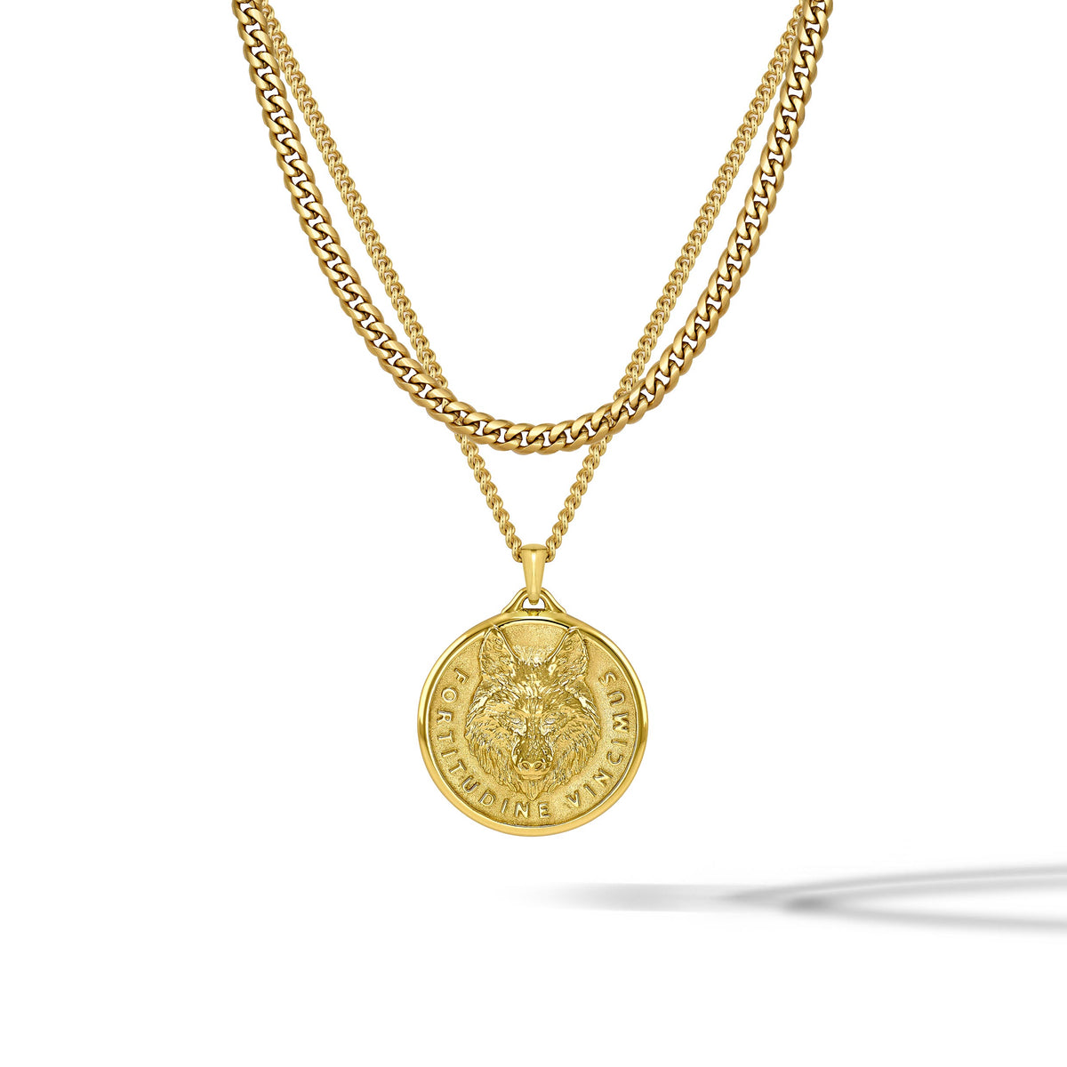 A gold double-layer necklace featuring a curb chain and a cable chain with a circular wolf pendant, shown against a plain white background with a soft shadow.