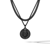 A black double-layered necklace featuring a thick curb chain and a delicate cable chain with a circular medallion pendant depicting a wolf head and the text 'CANIS LUPUS'.